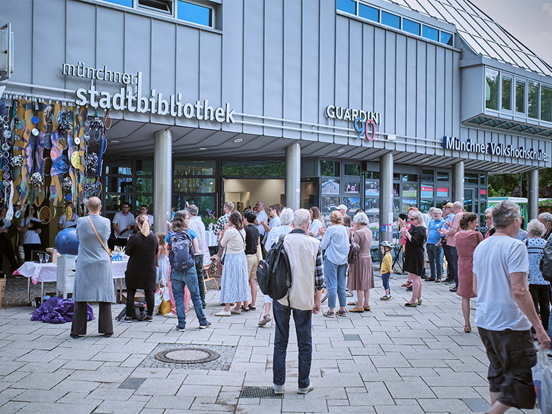 Hier stehen sehr viele Menschen vor dem großen Haus und feiern den 6. Geburtstag des Stadtteilkulturzentrums Guardini90.